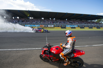 Stoner watches his V8 Supercar in action from the seat of a production Honda motorcycle at February's Top Gear Festival