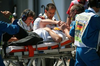 Cameraman Paul Allen being carted off after being struck by Mark Webber's wheel